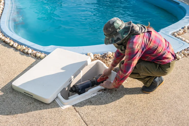 person accessing pool pump