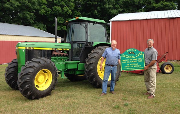 Carl Vuk accepts his Centennial Farm marker from UPPCO’s Dan Crane. The Vuk farm in L’anse was founded in 1914.